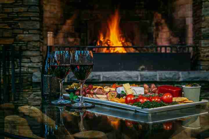 Wine and dine in corporate luxury, cheese platter with fireplace at Kauri Springs