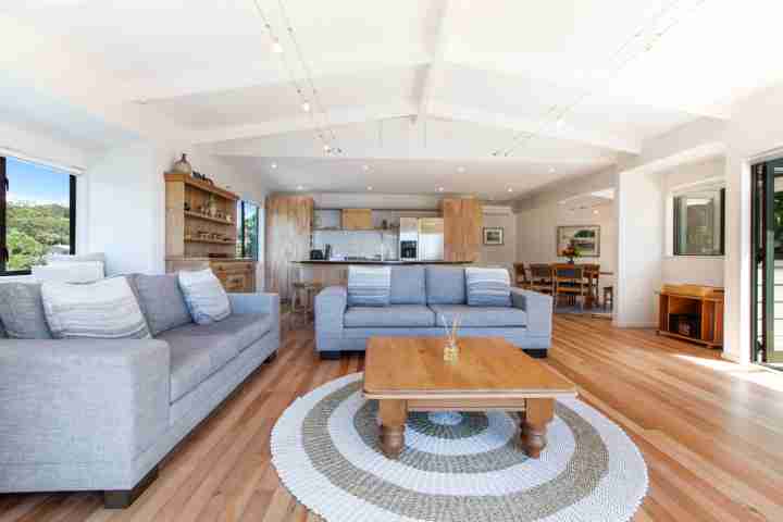 Modern open-plan lounge and dining area at Beachfront Enclosure Bay on Waiheke Island