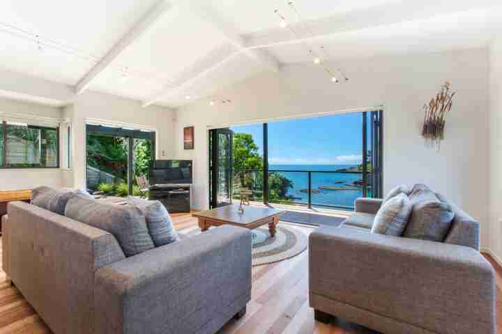 Family open-plan living area with private balcony and sea view at beachfront enclosure bay