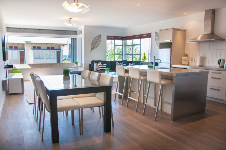 Open plan dining and kitchen area with breakfast bar at modern apartment