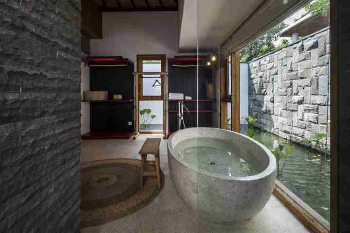 Large stone bathtub in five star bathroom with view of Japenese pond 