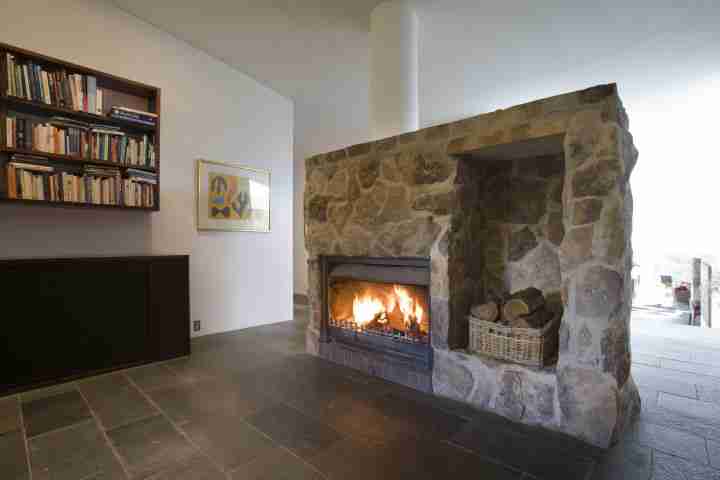 Large stone fireplace at the iconic Seidler House, private contemporary luxury holiday accommodation in Australia Southern Highlands