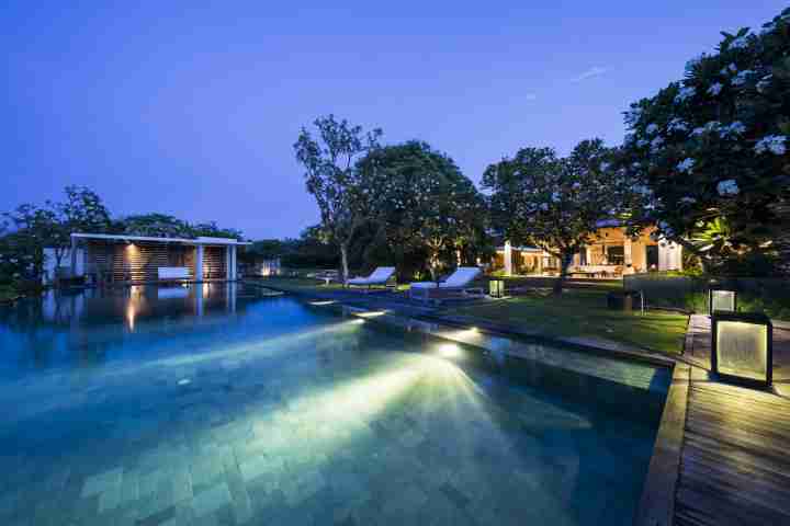 Uluwatu Estate infinity pool at night with ambient lighting