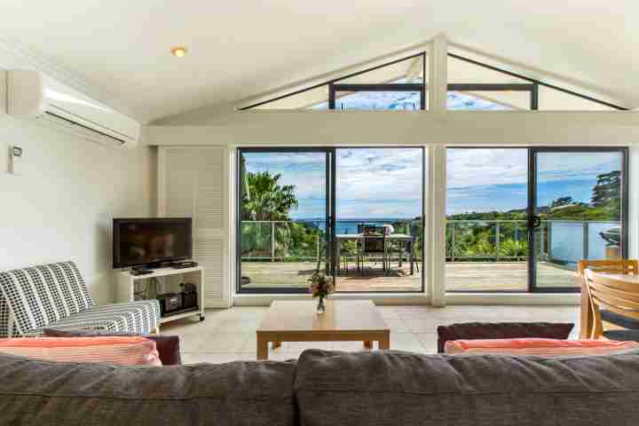 Comfortable lounge and TV area with outdoor deck and unlimited sea views of Waiheke