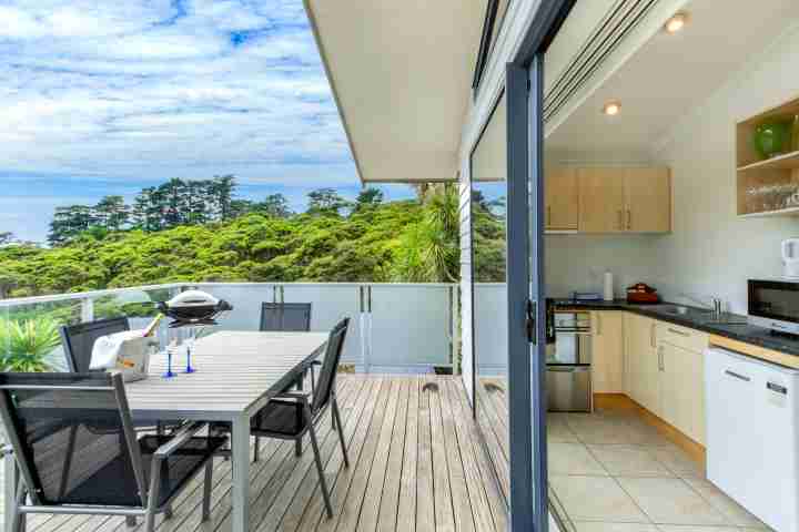 Outdoor dining table and seating area with BBQ, access from kitchen and lounge