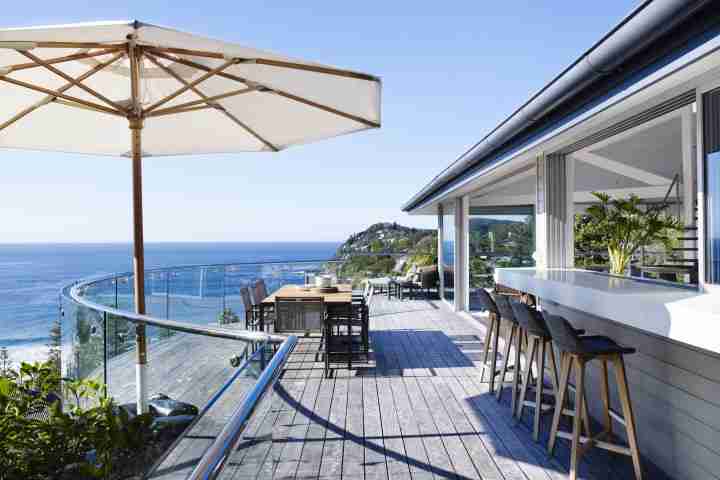 Large sunny deck with outdoor dining area and breakfast bar at luxury accommodation Australia