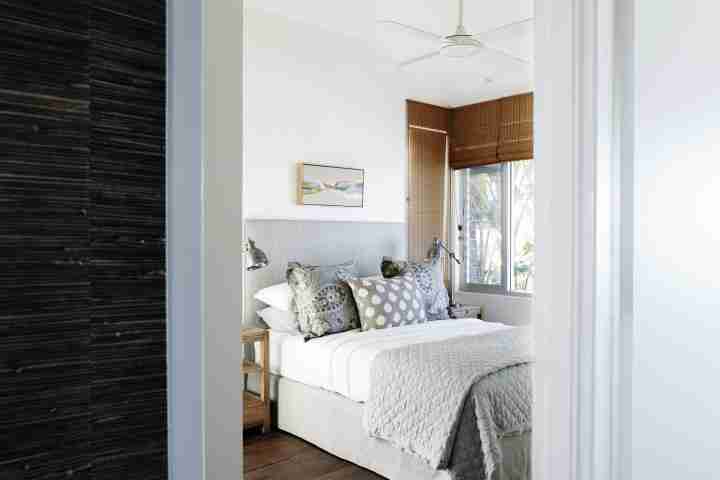 Comfortable double bed with bamboo blinds and ceiling fan at Whale Beach House, Luxury family accommodation Amaroo