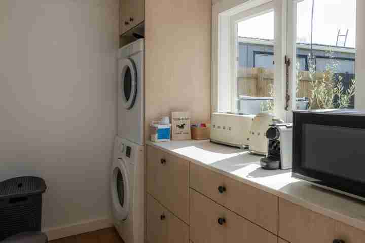 Full laundry area and additional ktichen space at Tahatai Cottage